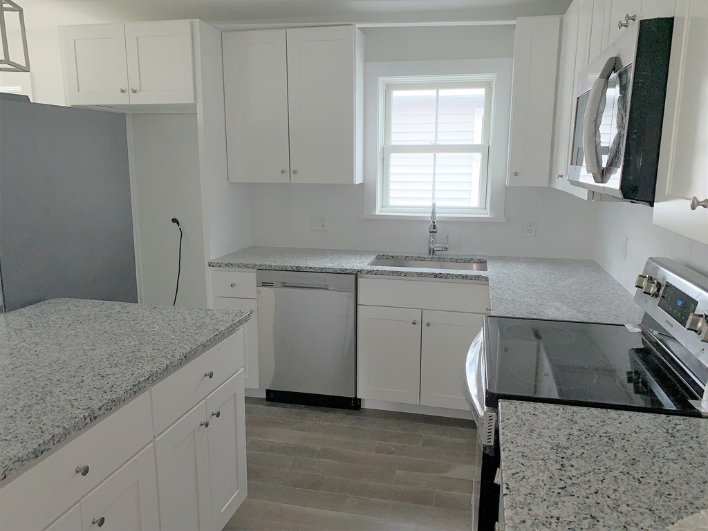 17 North End Boulevard, Unit A Salisbury, MA 01952 - Photo 2 of 13 a kitchen with a sink cabinets and window