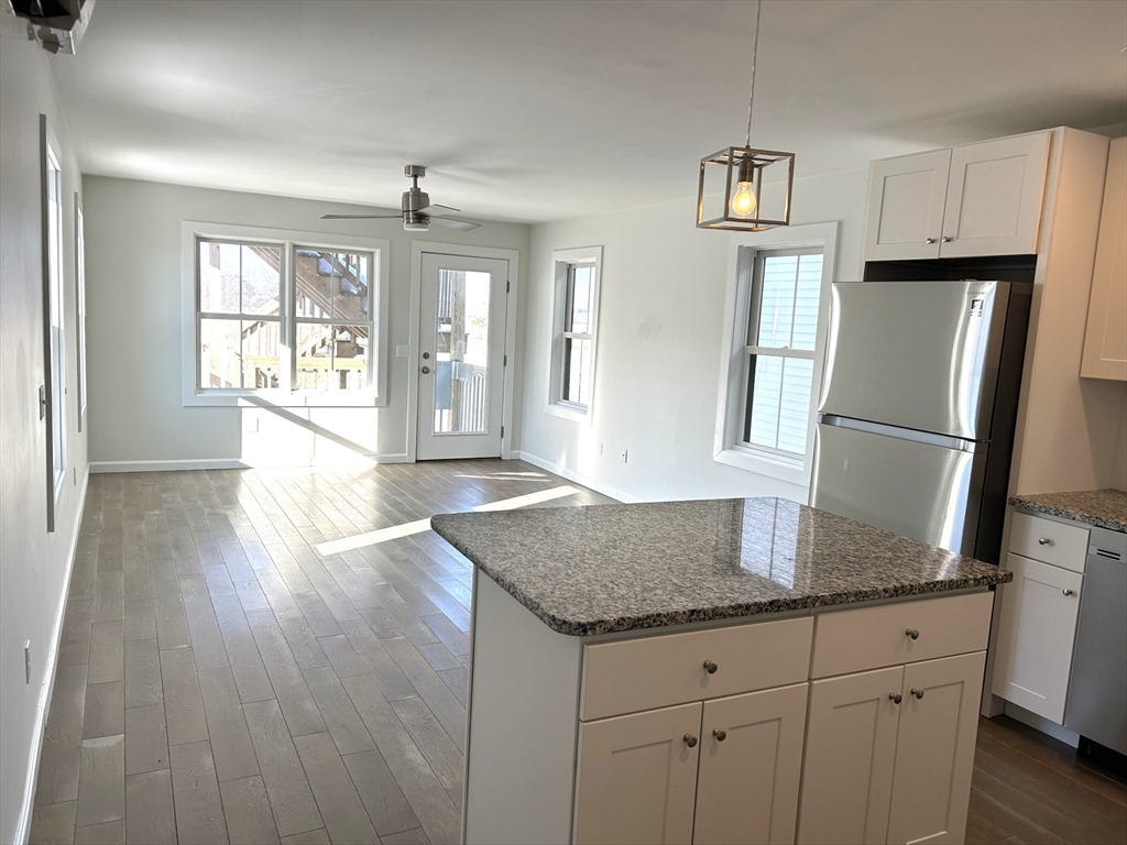 17 North End Boulevard, Unit A Salisbury, MA 01952 - Photo 2 of 13 a kitchen with granite countertop a refrigerator and a sink