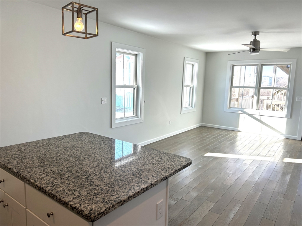 17 North End Boulevard, Unit A Salisbury, MA 01952 - Photo 3 of 13 an empty room with wooden floor and windows