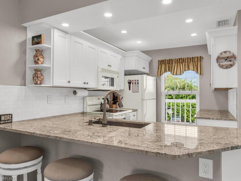 a kitchen with kitchen island granite countertop a stove a sink and a granite counter tops