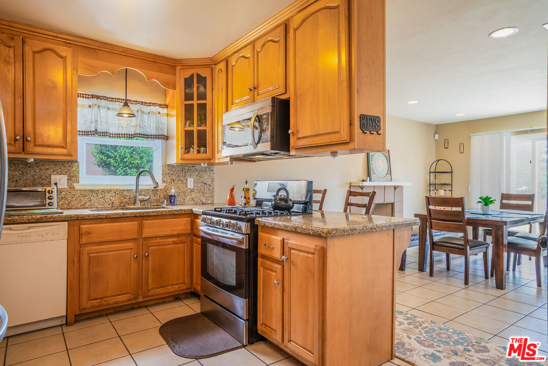 983 East Margarita Road Rialto, CA 92376 - Photo 11 of 23 a kitchen with stainless steel appliances granite countertop sink stove and cabinets