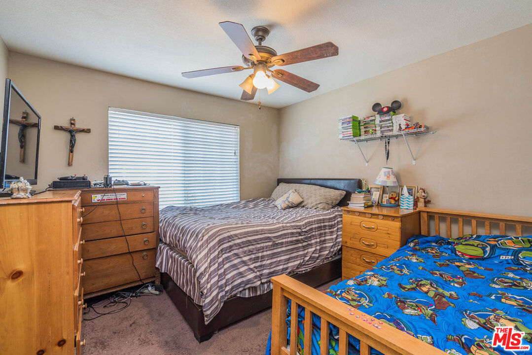 983 East Margarita Road Rialto, CA 92376 - Photo 14 of 23 a bedroom with two beds and a chandelier