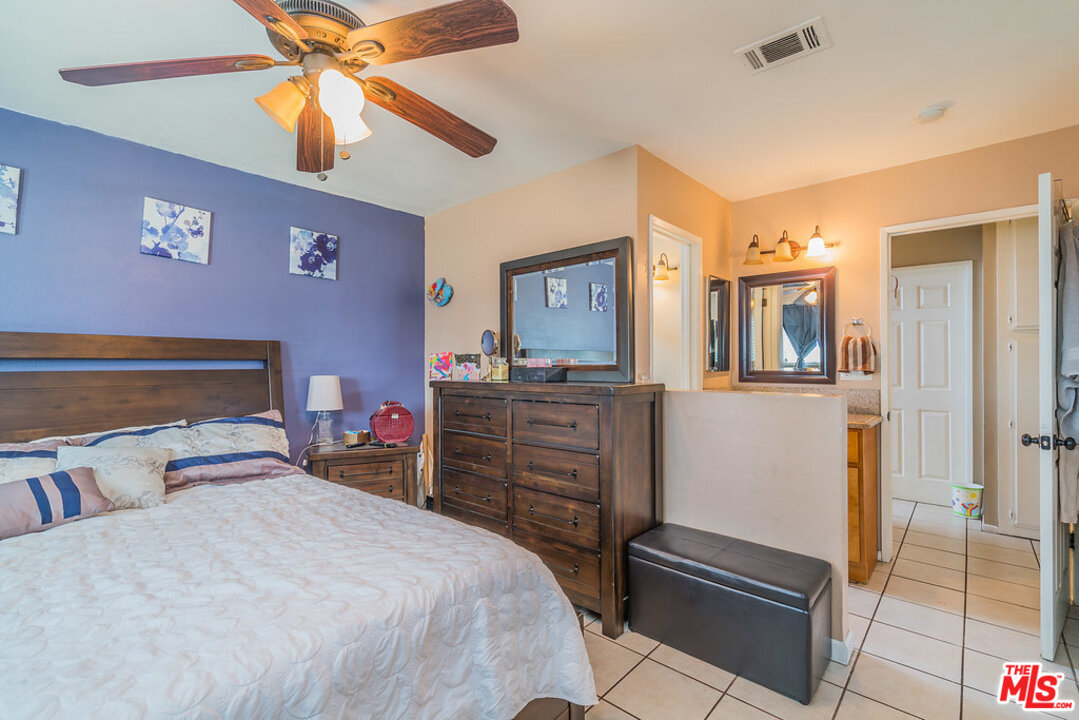 983 East Margarita Road Rialto, CA 92376 - Photo 17 of 23 a bedroom with a bed and a chandelier