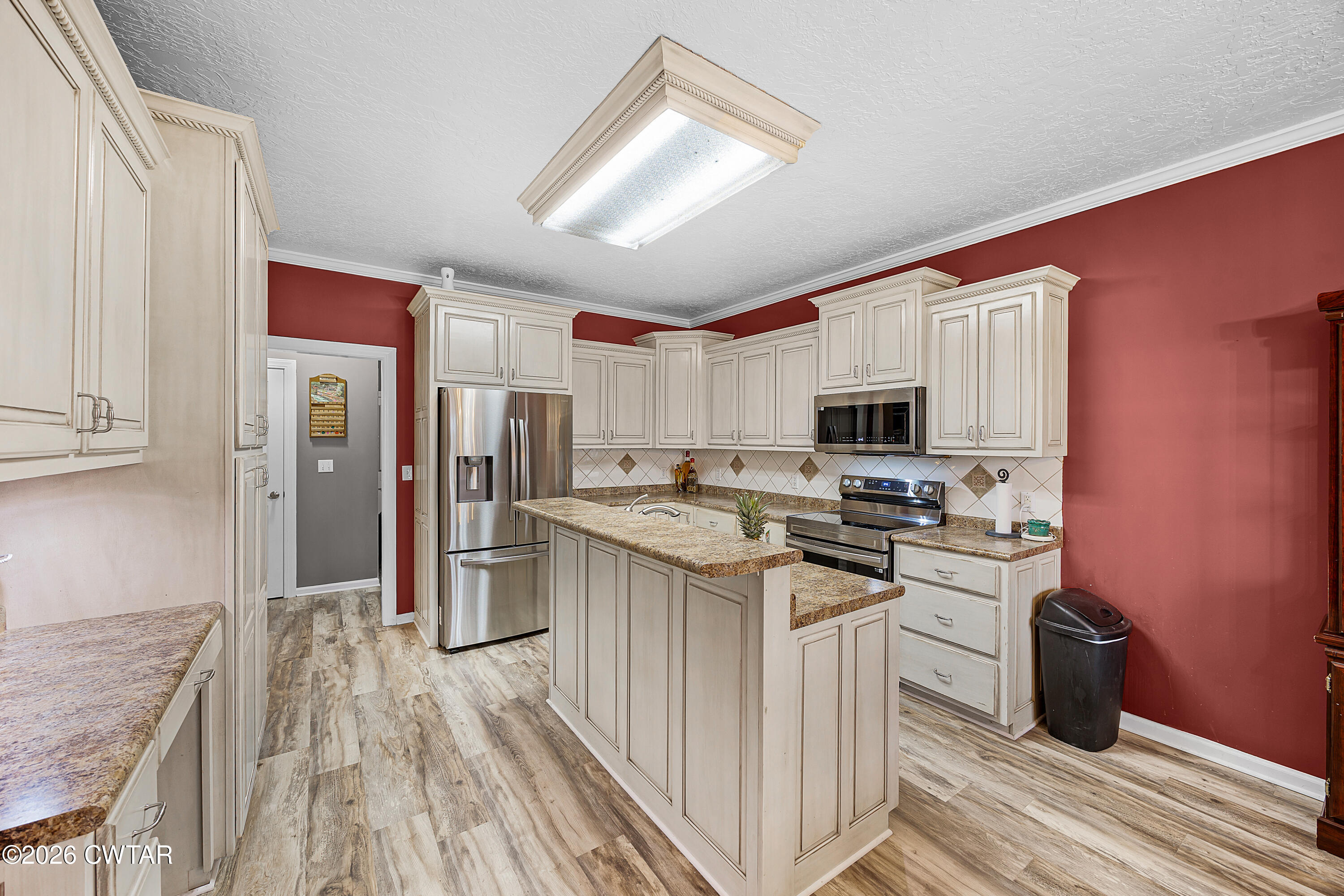 31 Turkey Creek Road Medina, TN 38355 - Photo 11 of 30 a kitchen with stainless steel appliances granite countertop a refrigerator a stove top oven a sink dishwasher and wooden cabinets with wooden floor