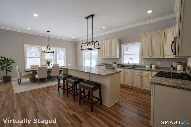 a kitchen with stainless steel appliances granite countertop wooden floors stove top oven and cabinets
