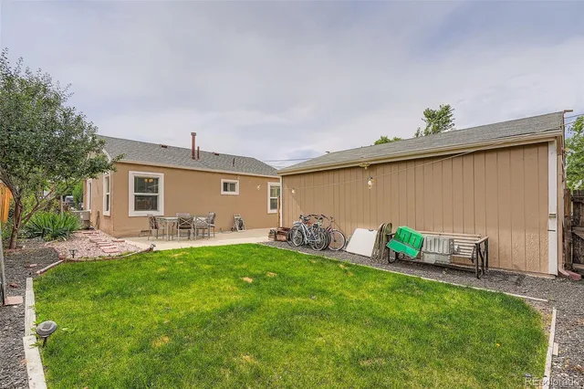 a backyard of a house with table and chairs