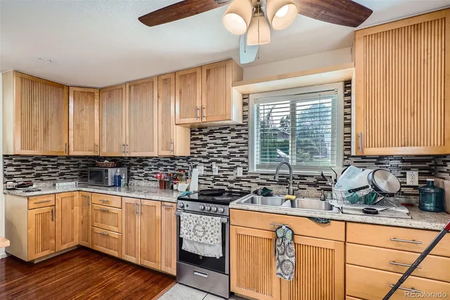 a kitchen with stainless steel appliances a sink a stove a counter space and cabinets