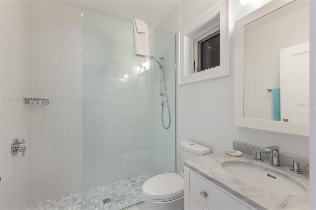 2031 Shore Lane Boca Grande, FL 33921 - Photo 42 of 100 a bathroom with a granite countertop sink toilet a mirror and shower