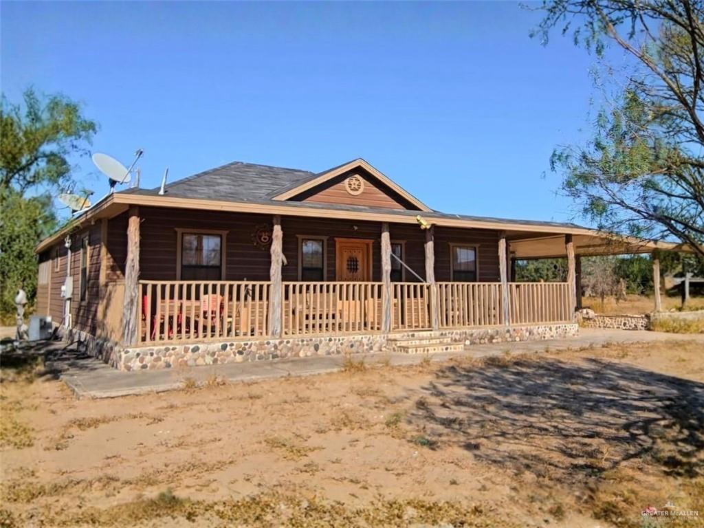 View of front of property featuring covered porch and faux log siding