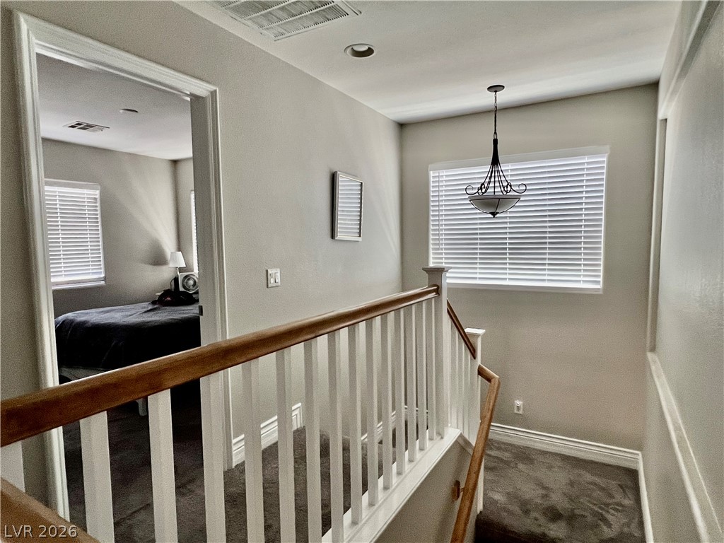 151 Short Ruff Way Las Vegas, NV 89148 - Photo 6 of 17 A spacious upper landing showcases plush carpeting and traditional wooden balustrades leading downstairs.