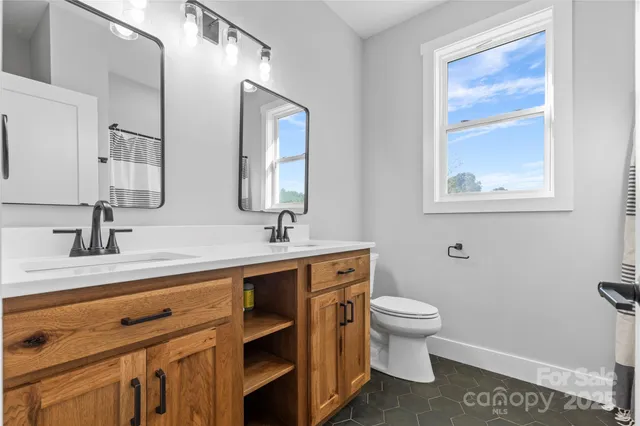 a bathroom with a sink a toilet and a mirror