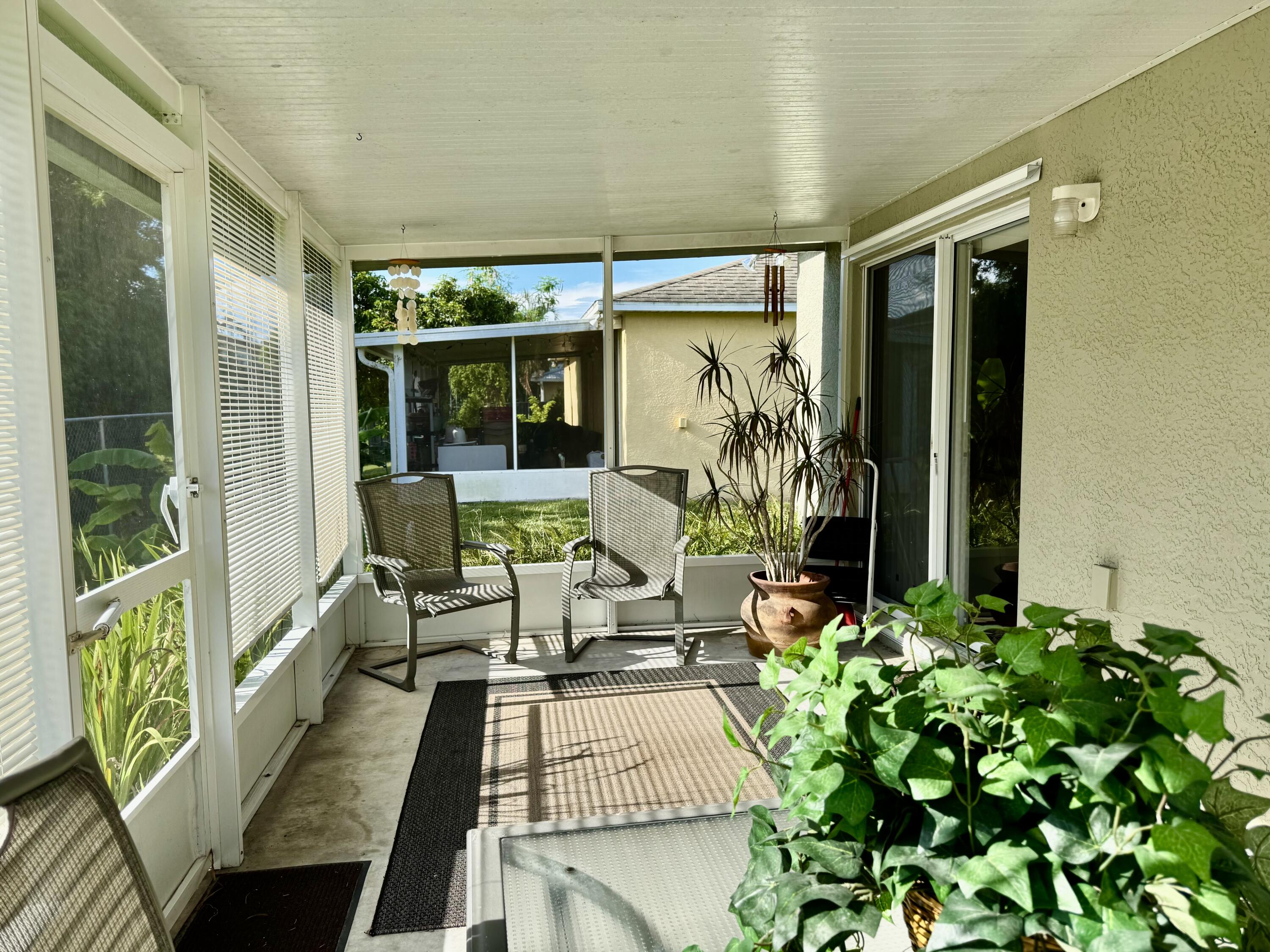 527 Southeast 38th Avenue Okeechobee, FL 34974 - Photo 25 of 30 a view of a patio with table and chairs potted plants and floor to ceiling window