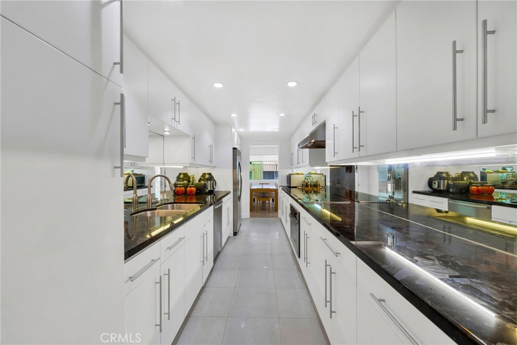 7259 Hillside Avenue, Unit 102 Los Angeles, CA 90046 - Photo 12 of 37 a large kitchen with stainless steel appliances lots of counter space and wooden floor