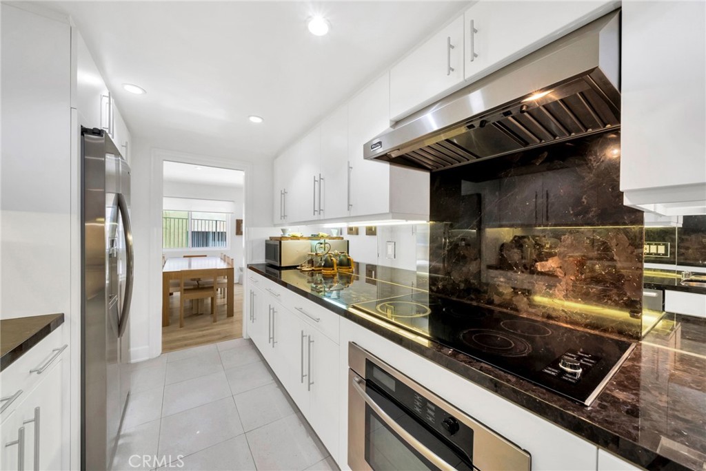 7259 Hillside Avenue, Unit 102 Los Angeles, CA 90046 - Photo 14 of 37 a kitchen with stainless steel appliances granite countertop a stove a sink and a refrigerator
