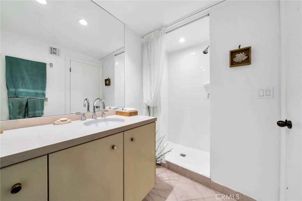 7259 Hillside Avenue, Unit 102 Los Angeles, CA 90046 - Photo 18 of 37 a en suite bathroom with a sink and a mirror
