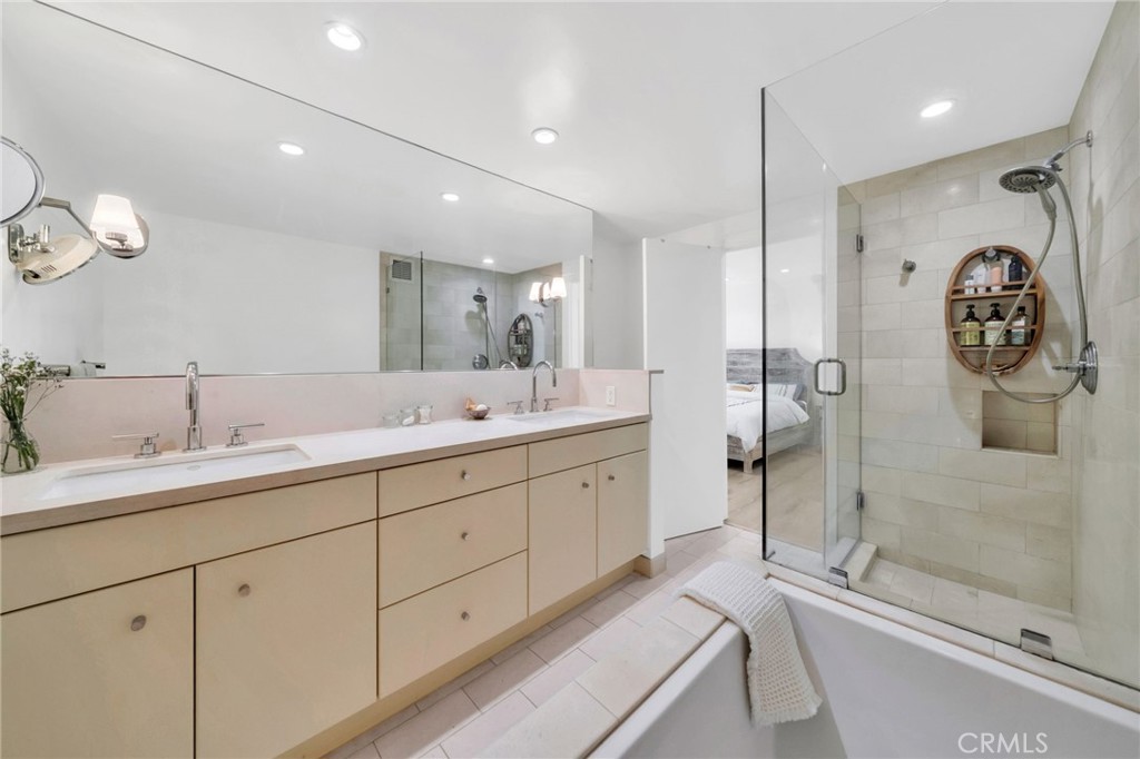 7259 Hillside Avenue, Unit 102 Los Angeles, CA 90046 - Photo 28 of 37 a spacious bathroom with a shower sink and mirror
