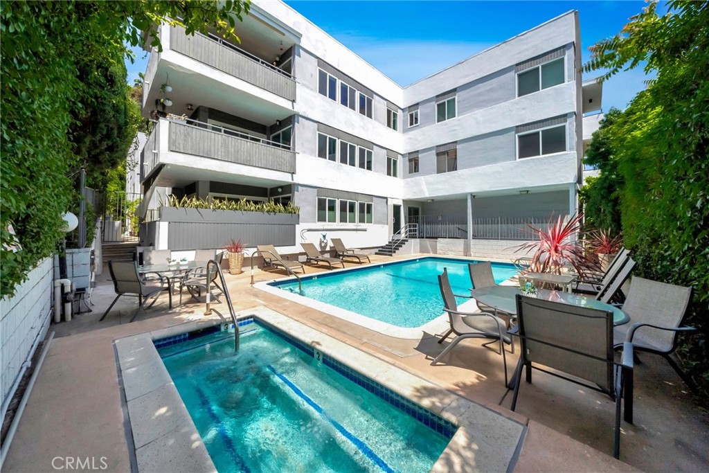 7259 Hillside Avenue, Unit 102 Los Angeles, CA 90046 - Photo 5 of 37 a view of a swimming pool with chairs and a patio