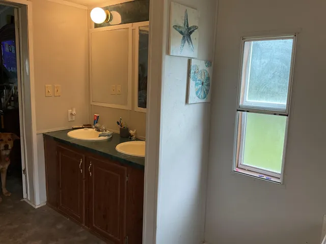 a bathroom with a granite countertop sink and a mirror