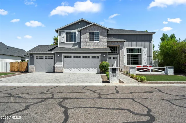 a front view of a house with a yard and potted plants