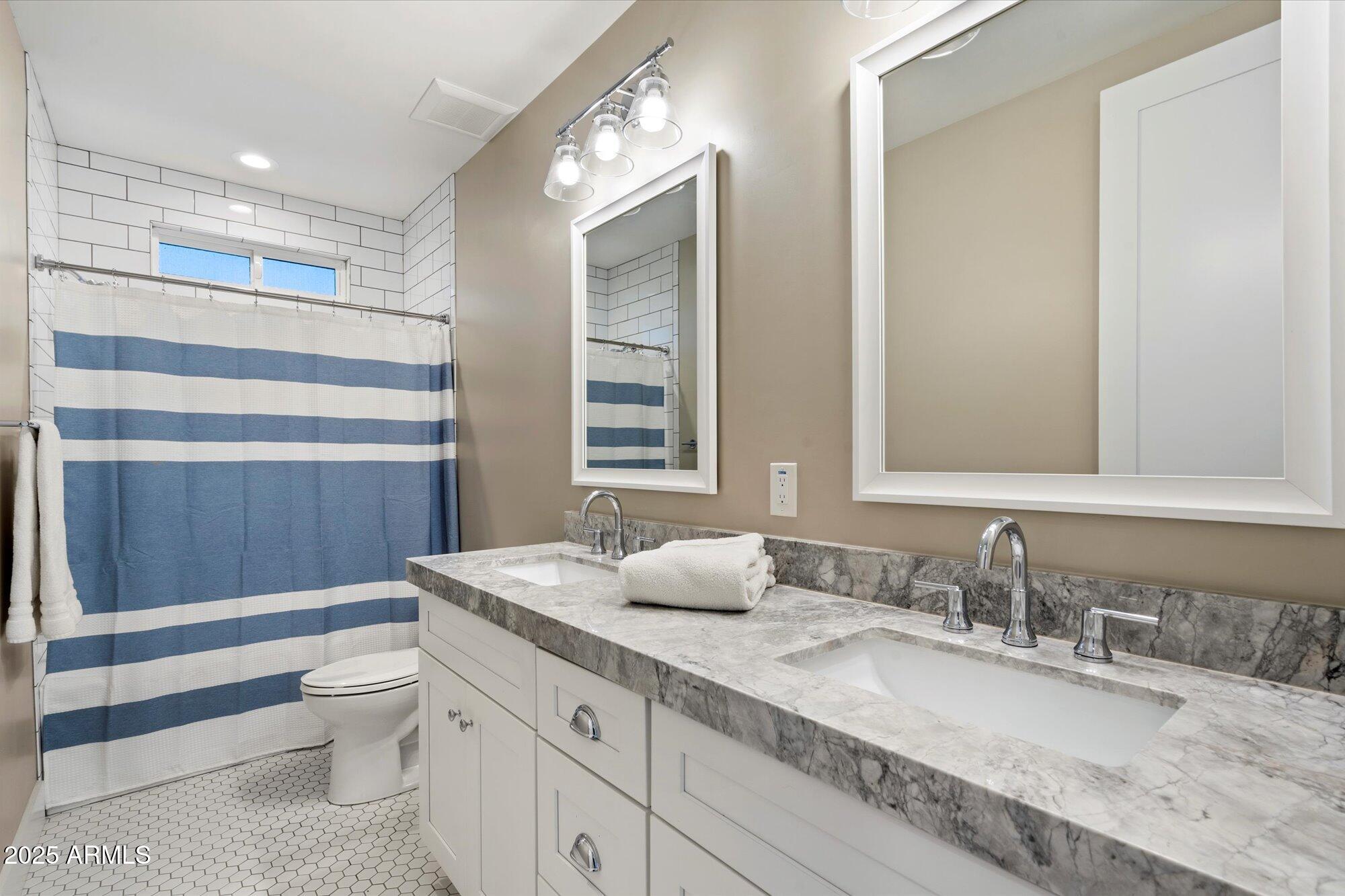 3810 East Devonshire Avenue Phoenix, AZ 85018 - Photo 18 of 34 a bathroom with a granite countertop sink a toilet a mirror and shower