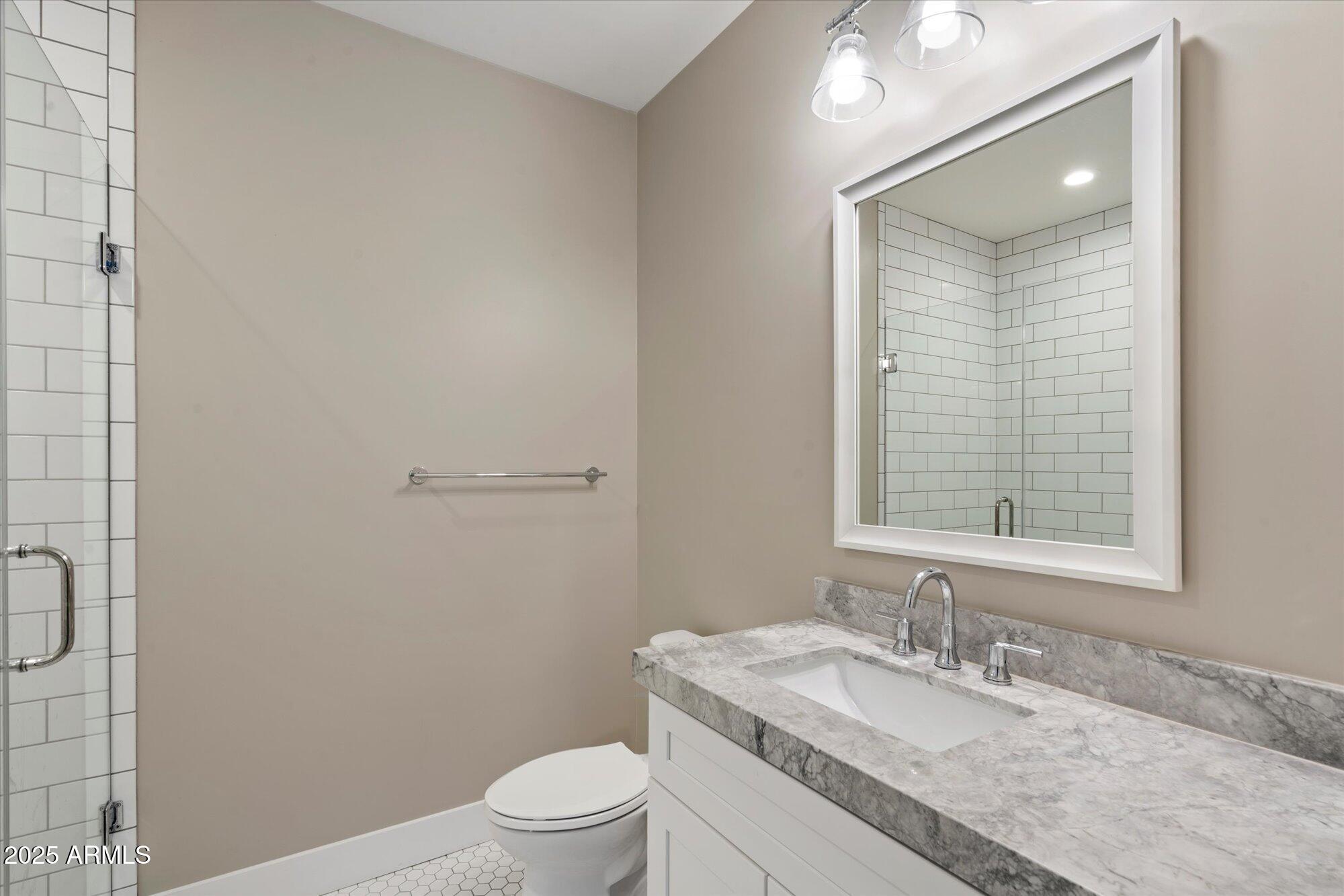 3810 East Devonshire Avenue Phoenix, AZ 85018 - Photo 22 of 34 a bathroom with a granite countertop sink toilet a mirror and shower