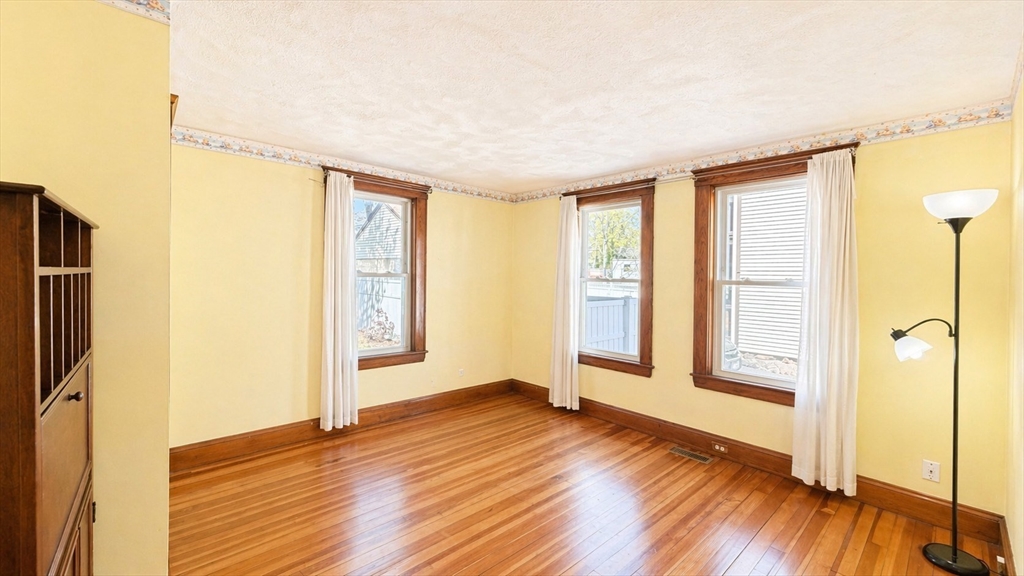 86 Howard Street, Unit 1 Waltham, MA 02451 - Photo 11 of 22 a view of an empty room with window and wooden floor
