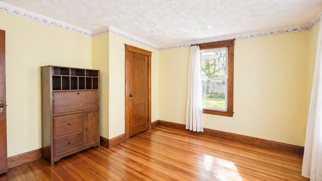 86 Howard Street, Unit 1 Waltham, MA 02451 - Photo 12 of 22 a view of empty room with wooden floor and fan