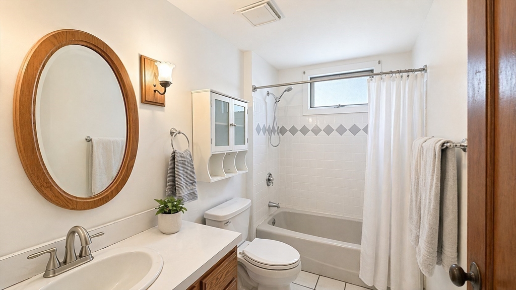 86 Howard Street, Unit 1 Waltham, MA 02451 - Photo 13 of 22 a bathroom with a sink a mirror a toilet and a mirror