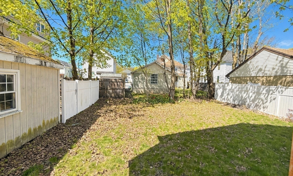 86 Howard Street, Unit 1 Waltham, MA 02451 - Photo 18 of 22 a yellow house with trees in front of it