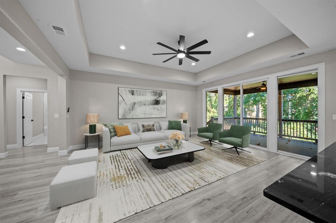 105 Bree Drive Anderson, SC 29621 - Photo 38 of 48 A well-lit living space features a tray ceiling, recessed lighting, and direct access to an outdoor area.