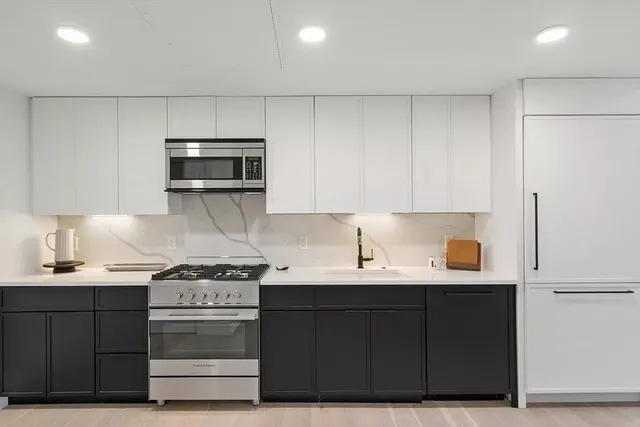 a kitchen with stainless steel appliances a sink stove and cabinets