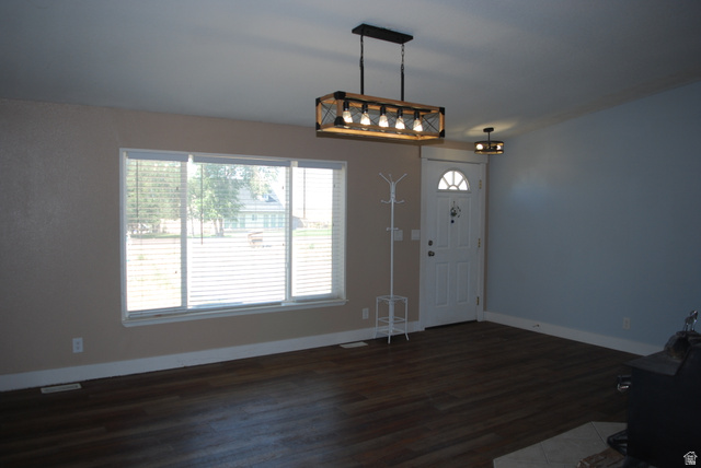 1055 West Ashby Road Delta, UT 84624 - Photo 5 of 44 Open-concept room featuring wood-finish flooring, a white front door with an arched window, and a modern rectangular chandelier
