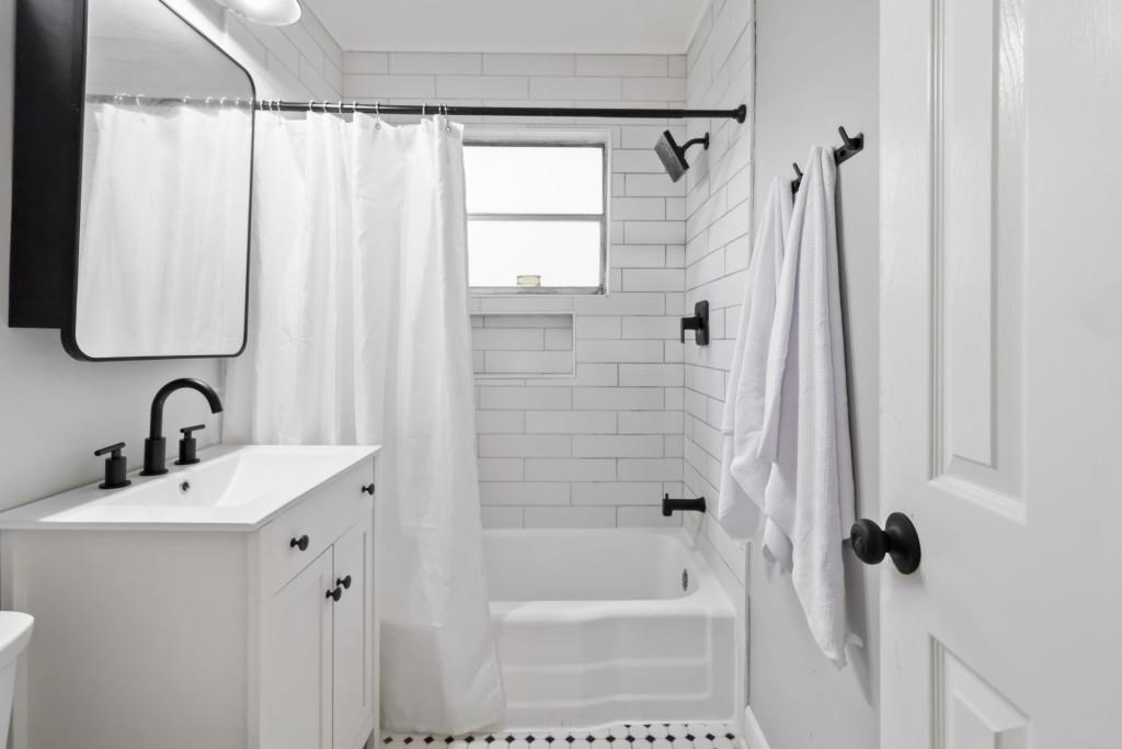 816 Piedmont Avenue Northeast, Unit 1 Atlanta, GA 30308 - Photo 5 of 21 a bathroom with a shower a sink a mirror a vanity and a shower