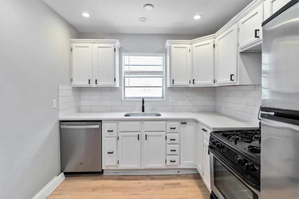 816 Piedmont Avenue Northeast, Unit 1 Atlanta, GA 30308 - Photo 10 of 21 a kitchen with stainless steel appliances white cabinets and a stove top oven