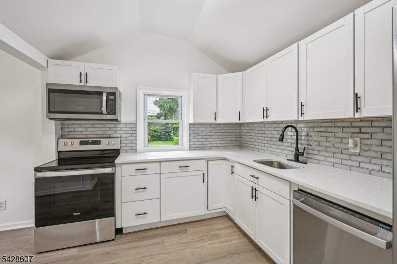223 Waconia Road Vernon, NJ 07422 - Photo 11 of 26 a kitchen with cabinets stainless steel appliances a sink and wooden floor