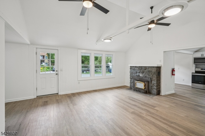 223 Waconia Road Vernon, NJ 07422 - Photo 5 of 26 an empty room with windows fireplace and wooden floor