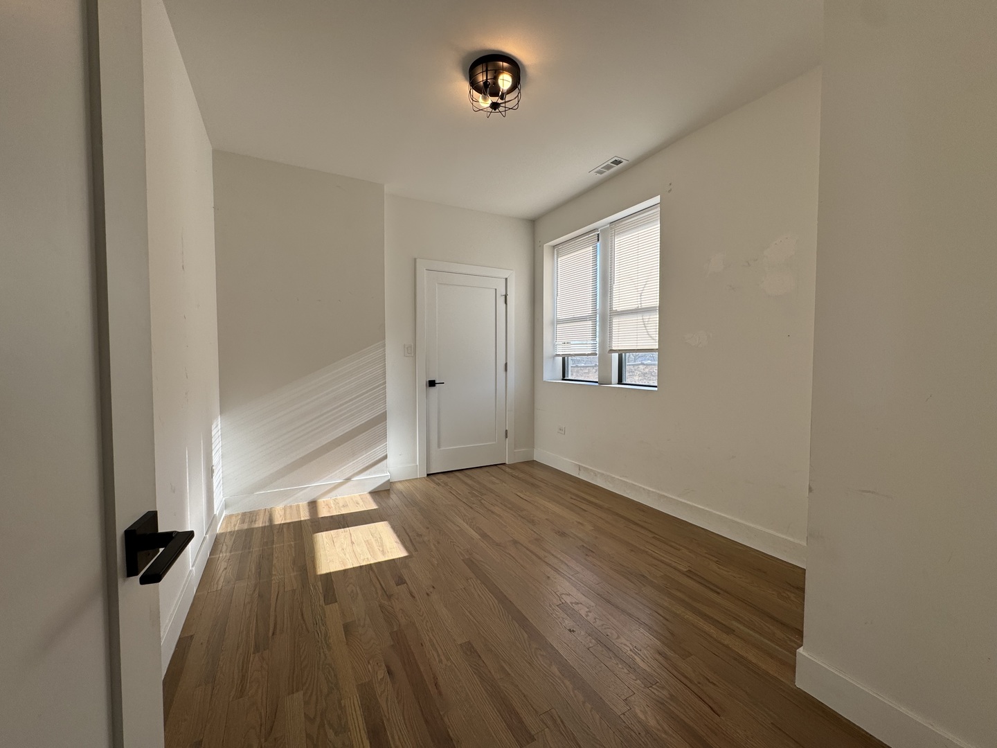 1303 South California Avenue, Unit 4W Chicago, IL 60608 - Photo 8 of 12 an empty room with wooden floor and windows
