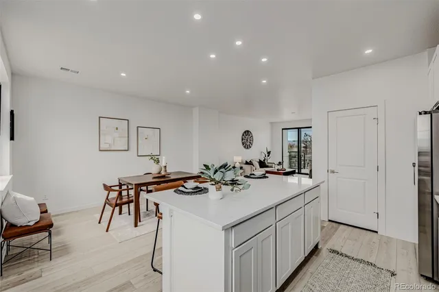 a kitchen with stainless steel appliances kitchen island granite countertop a sink a stove and a white cabinets