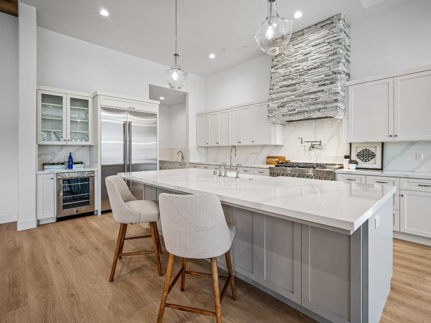 8118 Bridger Lane Shingle Springs, CA 95682 - Photo 13 of 59 a kitchen with stainless steel appliances kitchen island a table chairs in it and white cabinets