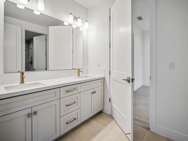 a bed sitting in a spacious bedroom next to a window with a fireplace