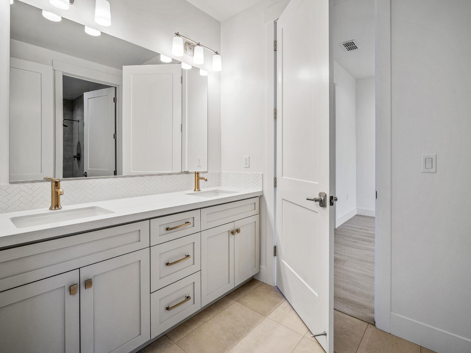 8118 Bridger Lane Shingle Springs, CA 95682 - Photo 18 of 59 a bathroom with a double vanity sink and mirror