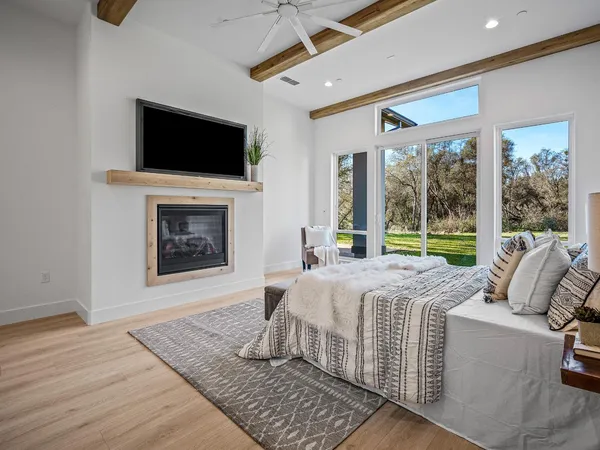 an empty room with wooden floor ceiling fan and windows
