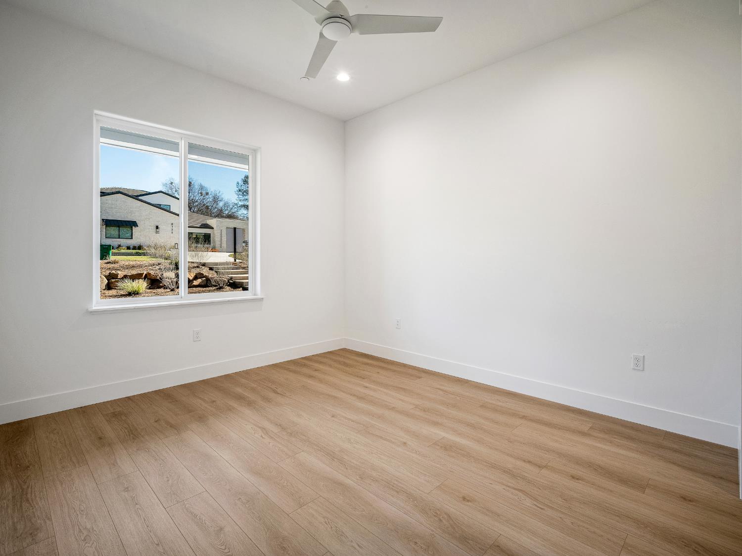 8118 Bridger Lane Shingle Springs, CA 95682 - Photo 27 of 59 an empty room with wooden floor ceiling fan and windows