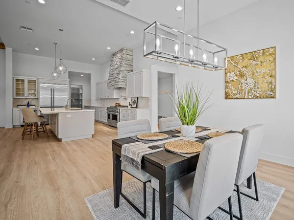 a kitchen with white cabinets and wooden floor