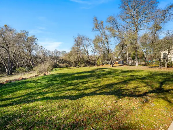 a view of a house with a big yard and large trees