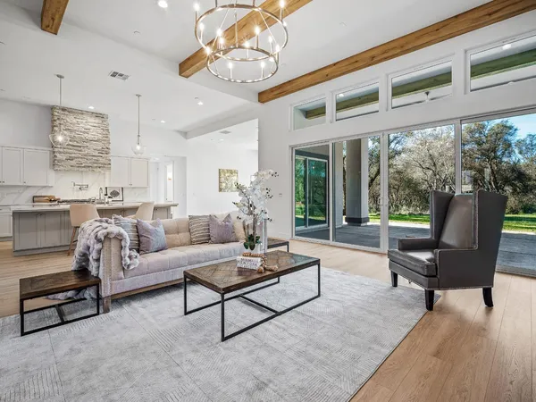 a living room with furniture a chandelier and a dining table