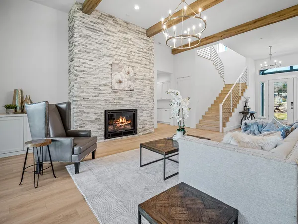 a kitchen with stainless steel appliances kitchen island a table chairs in it and white cabinets