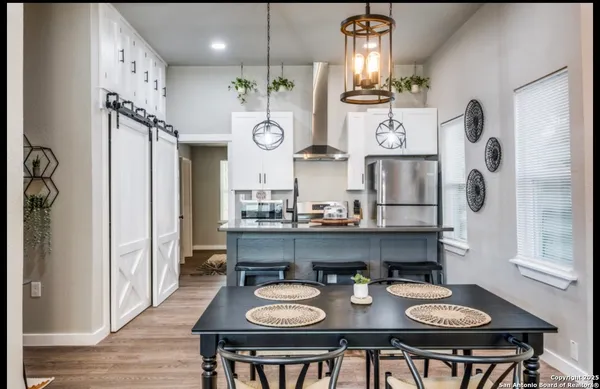 a open dining room with furniture and chandelier