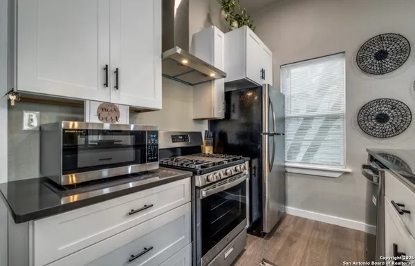 a kitchen with stainless steel appliances a stove a refrigerator and a cabinets
