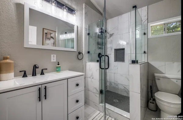 a bathroom with a granite countertop sink toilet and shower